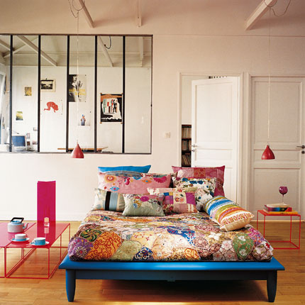 En säng placerad mitt i rummet kan fungera som en skön dagbädd eller soffa. 