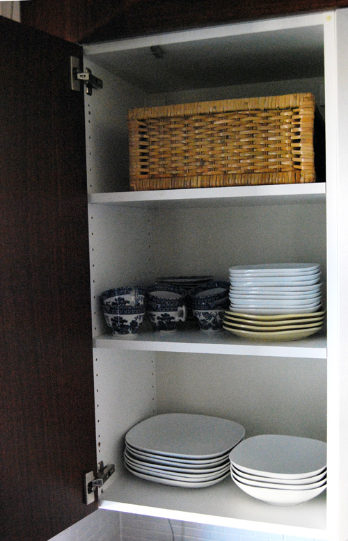 Plastick jars are stored in the top of the kitchen cabinet.